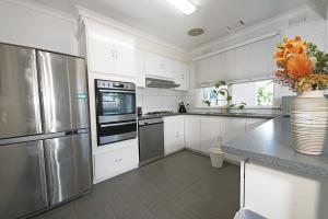 帕克德尔Pet-friendly Bayside 4BR Rental House near Mentone的厨房配有白色橱柜和不锈钢用具