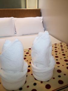 马尼拉Bliss by John at Sea Residences的两叠毛巾,放在床上