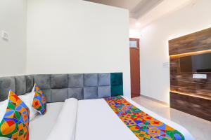 瓜廖尔FabExpress Royal Villas的卧室配有一张床,墙上配有电视。