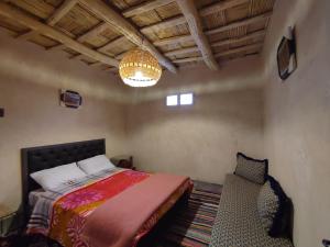 凯拉Maroc des Merveilles - Chez L'habitant的一间卧室配有一张床、吊灯和椅子