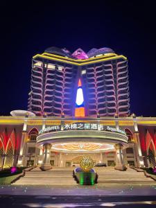 金三角Seamsak hotel的一座大建筑,晚上有标志