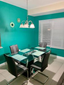 卢西Aquamarine Resort-style Vacations的一间拥有绿色墙壁和桌椅的用餐室