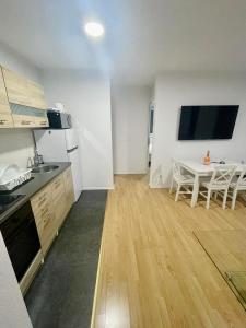 卢布尔雅那MURIC Apartman 8的一间带桌子的厨房和一间带用餐室的小厨房