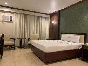 卡加盐德奥罗多乐事豪华酒店的卧室配有一张床和一张桌子及椅子