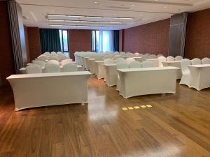 台州台州远洲逸廷酒店的一间会议室,配有白色椅子和木地板