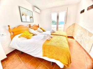 伊斯坦Casa Rural Manantial de las Jaras的卧室配有一张白色大床和黄色床单