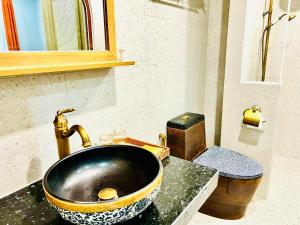 富国Rova Hotel Phú Quốc的一间带金色水龙头水槽的浴室