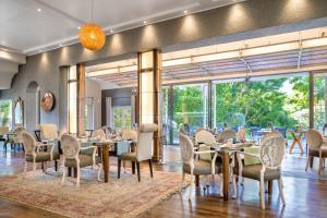 开普敦葡萄园酒店的用餐室配有桌椅和大窗户