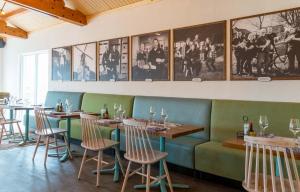 OttolandFamilie Resort Molenwaard的餐厅设有桌椅,墙上挂有图片