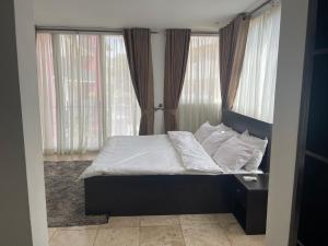 阿克拉Luxury @ the Garden的卧室内的一张带白色床单和枕头的床