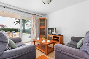卡兰博希Villas Calan Bosch Emily的客厅配有两张沙发和一台电视