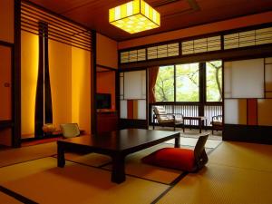砺波市三乐园日式旅馆的一间带茶几的客厅和一间带阳台的房间
