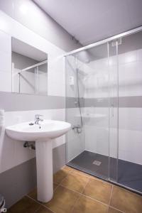 麦德林里约旅馆的一间带水槽和玻璃淋浴的浴室