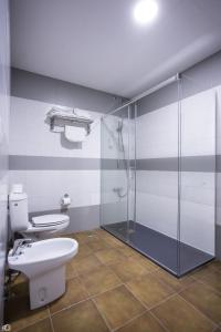 麦德林里约旅馆的一间带卫生间和玻璃淋浴间的浴室