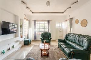 纳库鲁North Manor Nakuru的客厅配有绿色沙发和桌子