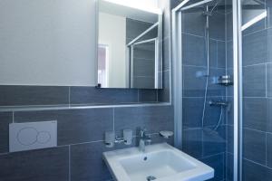 苏黎世HITrental Wiedikon Apartments的一间带水槽、镜子和淋浴的浴室