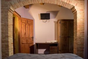 Poveda de la SierraHospedaje Rural Casa Parri的一间卧室设有拱门、一张床和电视。