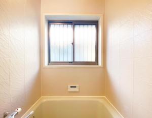高知The Domain的带浴缸的浴室和窗户