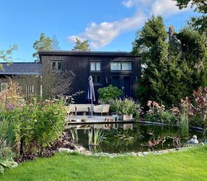 StenhamraOrres Guesthouse Stenhamra, Ekerö的前面有池塘的房子