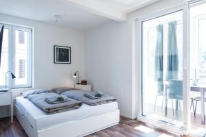 苏黎世HITrental Wiedikon Apartments的白色的卧室设有床和窗户