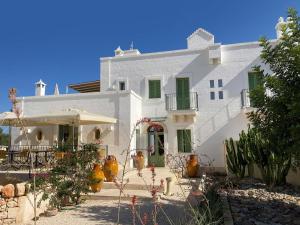 萨维勒特里Boutique Hotel Masseria Sottomasi的前面有植物的白色房子