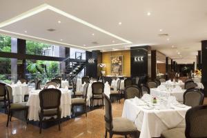 巴西利亚Windsor Plaza Brasilia的餐厅配有桌椅和白色桌布