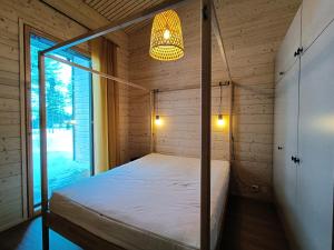 索特Villa Vaara的木制客房内的一间卧室,配有一张床