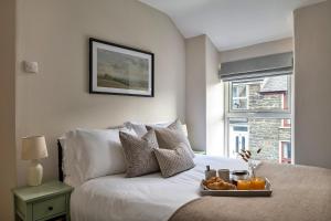 布莱奈费斯蒂尼奥格Finest Retreats - Bwthyn Llechi, Slate Cottage的一间卧室配有一张床,上面放着一个食物托盘