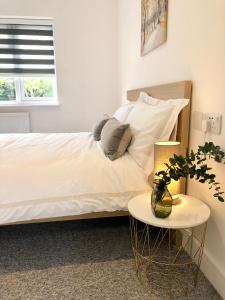 牛津Spacious En-suite Private Double Bedroom的一张带白色床单和枕头的床以及一张桌子