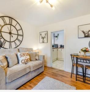 布里奇诺斯Bernards Hill的客厅配有沙发和墙上的时钟