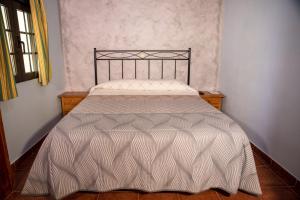 Poveda de la SierraHospedaje Rural Casa Parri的客房内的一张带白色棉被的床