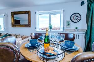 Bodelwyddan"Woodlands" by Greenstay Serviced Accommodation - Luxury 3 Bed Cottage In North Wales With Stunning Countryside Views & Parking - Close To Glan Clwyd Hospital - The Perfect Choice for Contractors, Business Travellers, Families and Groups的一张桌子,上面放着一瓶葡萄酒和酒杯