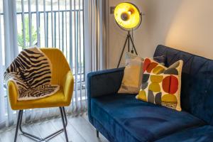 斯坦斯Ashview 2 - Heathrow - Thorpe Park - Free Parking的客厅里设有蓝色的沙发和黄色的椅子