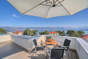 斯拉汀Aquamarin - Premium Seaview Apartment的阳台配有桌椅和遮阳伞。