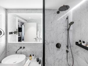 维也纳The Amauris Vienna - Relais & Châteaux的带淋浴和盥洗盆的白色浴室