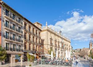 格拉纳达Hotel Macià Plaza的城市中拥有建筑和人的街道