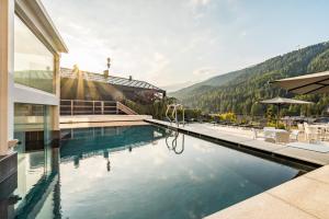 梅扎纳Hotel Ravelli Luxury Spa的一座山前的游泳池