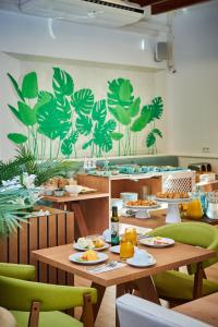 科洛尼亚圣霍尔迪Hotel Colonial的餐厅设有木桌和绿色椅子