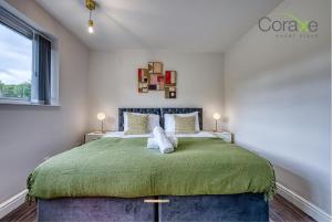 达德利3 Bedroom Luxe Living for Contractors and Families by Coraxe Short Stays的一间卧室配有一张带绿毯的大床