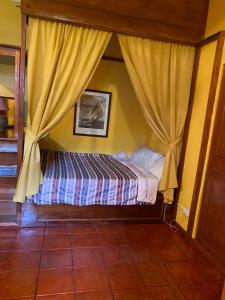 麦克坦德尔马尔别墅的一间卧室配有一张带天蓬和窗帘的床