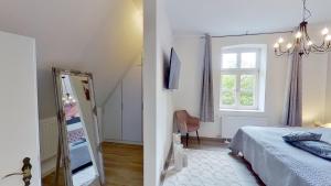 PutgartenFerienwohnung Leuchtturmwärter的一间卧室设有一张床、一个窗口和一面镜子