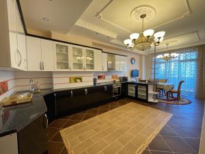 巴库Park Azure Residence的一间厨房,配有白色橱柜和一间餐厅