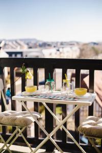 卡布尔Appartement cosy avec vue imprenable sur Cabourg - accès direct plage - proche centre ville的阳台上的白色桌子和玻璃杯