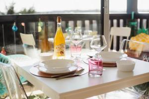 卡布尔Appartement cosy avec vue imprenable sur Cabourg - accès direct plage - proche centre ville的一张桌子,上面放着两杯酒和一瓶葡萄酒