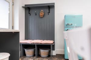 唐克斯特The Laurel Cottage的浴室设有蓝色门,在架子上装有篮子