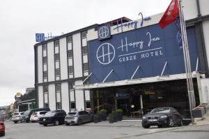 科贾埃利Happy Inn Gebze Hotel的一座大型建筑,前面有汽车停放