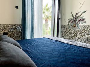 普罗塔拉斯Mosaic villa by the sea的一间卧室设有蓝色的床和窗户。