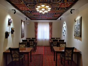希瓦Islam Khodja的一间带桌椅和天花板的用餐室