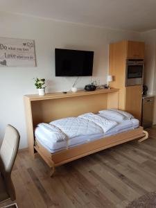 圣安德里斯伯格Dat-Harzchen-mit-Garage-und-WLAN的一间卧室设有一张带平面电视的床。
