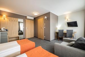 比亚韦斯托克莱斯尼酒店的酒店客房配有床、沙发和桌子。